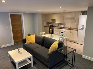 uma sala de estar com um sofá e uma cozinha em Stylish 1 Bedroom, 2 bed Basement Flat With Free Parking em Sale