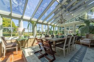 a conservatory with a table and chairs and a glass ceiling at The Old School House W in Warham