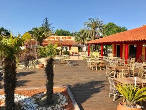 a patio with tables and chairs and a restaurant at 3 bedroom Chalets Camping de Pujol Argelès-sur-Mer - JoyCasa in Argelès-sur-Mer