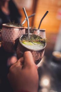 a person holding up two cups with plants in them at Hotel 8 al Mar in Pichilemu