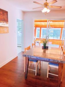 a dining room with a table and a ceiling fan at Riverside Harrison Hotsprings House in Harrison Hot Springs