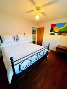 a bedroom with a large bed with a ceiling fan at Riverside Harrison Hotsprings House in Harrison Hot Springs