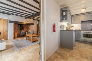 a kitchen and living room with a table and a stove at Creek Cottage in Wells next the Sea