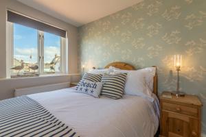 a bedroom with a bed and a window at Creek Cottage in Wells next the Sea