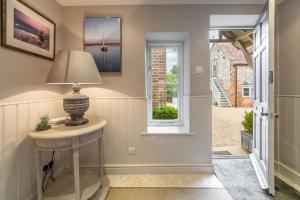 a hallway with a table and a window at The Little House in Brancaster