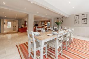 a dining room and living room with a table and chairs at The Little House in Brancaster