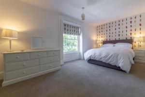 a bedroom with a large bed and a window at Chestnut Cottage in Thornham