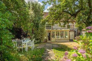 a house with a table and chairs in the garden at Chestnut Cottage in Thornham