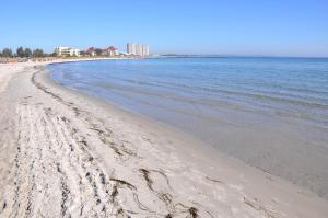 einen Strand mit Fußabdrücken im Sand und im Wasser in der Unterkunft Burgtiefe Südstrand "Sorglos" in Fehmarn