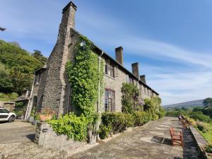 an old stone building with ivy on it at Luxury Bed And Breakfast at Bossington Hall in Exmoor, Somerset in Porlock