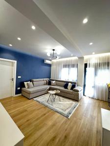 a living room with couches and a blue wall at Luxurious seaside apartment in Durrës