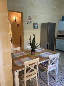 uma cozinha com uma mesa de madeira e um frigorífico em Villa Vella - 2 Bedroom House Gozo em Taʼ Abram