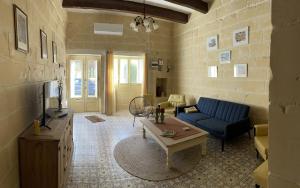 uma sala de estar com um sofá azul e uma mesa em Villa Vella - 2 Bedroom House Gozo em Taʼ Abram