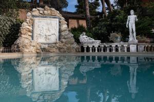 una estatua sentada junto a un charco de agua en Casa Romana, en Tor Vergata