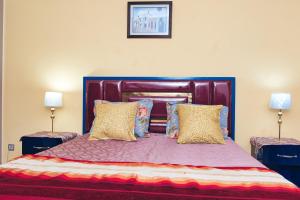 The Pearl Apartment Hammam Sousse WIFI في سوسة: غرفة نوم بسرير كبير فيها مصباحين