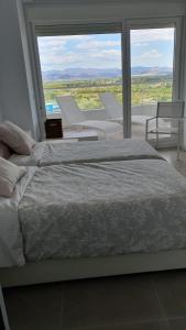 ein Schlafzimmer mit einem großen Bett und einem großen Fenster in der Unterkunft Apartamento con vistas en Gran Canet in Canet d'en Berenguer