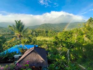 a rainbow over a mountain with a house and trees at Ling & Louie's Mountain in Mayong