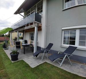 eine Terrasse mit 2 Stühlen und einem Tisch vor einem Haus in der Unterkunft Ferienwohnung Reinhold in Schönbrunn am Lusen in Hohenau