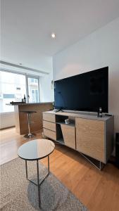 sala de estar con TV grande y mesa en Mexico City Apartment Palmas Polanco By Bamboo Skylife, en Ciudad de México