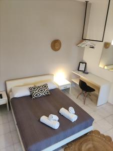 a bedroom with a bed with two towels on it at Galini Rooms & Apartments in Finikas