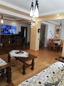 ein Wohnzimmer mit einem Tisch und einem TV in der Unterkunft Casa Din Padure in Sinaia