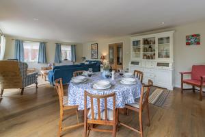 a dining room and living room with a table and chairs at Bettys Cottage in Brancaster