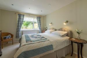 a bedroom with a bed and a window at Bettys Cottage in Brancaster