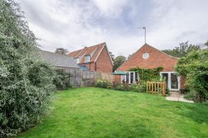 a backyard of a house with a fence at Bettys Cottage in Brancaster