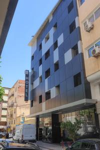 un edificio con una furgoneta estacionada frente a él en Hôtel Des Lilas, en Oujda