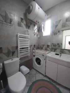 een badkamer met een toilet, een wastafel en een wasmachine bij Guest house B&B in Kochkorka