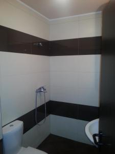 a bathroom with a shower and a toilet and a sink at Apartment Nova in Burgas City