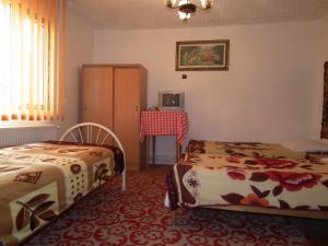 una camera con due letti e un tavolo di Pensiunea Irina 3 a Zărneşti Altre 167 foto