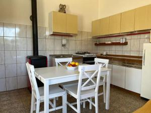 een keuken met een tafel met stoelen en een fruitschaal bij Holiday home Ante in Žirje