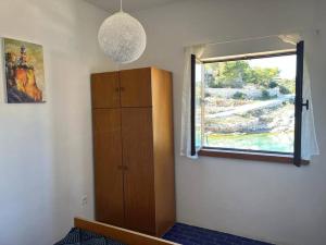 Habitación con armario de madera y ventana. en Holiday home Ante en Žirje