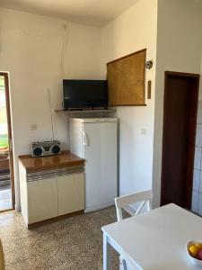 eine Küche mit einem weißen Kühlschrank und einem Tisch mit einem Tisch in der Unterkunft Holiday home Ante in Žirje