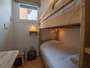 a bunk bed in a small room with a table at Charmant appart central avec parking à l'Alpe d'Huez - FR-1-645-18 in LʼHuez