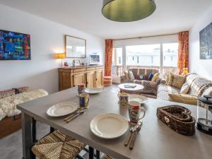 a living room with a table with plates on it at Charmant appart central avec parking à l'Alpe d'Huez - FR-1-645-18 in LʼHuez +9 photos