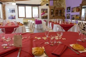 una habitación con mesas con mesas en rojo y blanco en Hotel Un lugar en la Vecilla en Dueñas