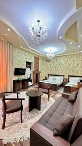 een woonkamer met een bank en een kroonluchter bij Boutique Hotel Mosaic in Samarkand