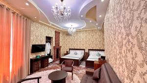 een slaapkamer met een bed, een bank en een kroonluchter bij Boutique Hotel Mosaic in Samarkand