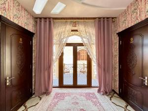 een kamer met een deur en een raam met gordijnen bij Boutique Hotel Mosaic in Samarkand