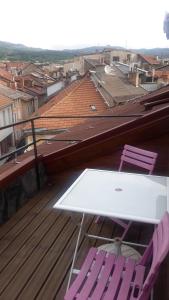 een witte tafel en twee paarse stoelen op een dak bij Appartement de caractère in Gap