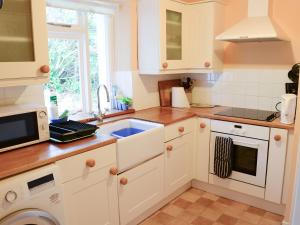 a kitchen with white cabinets and a sink at Farr in Helmsdale