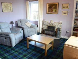 a living room with a couch and a fireplace at Farr in Helmsdale