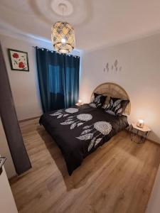a bedroom with a bed with a black comforter at Agréable T2 Classé 3 étoiles, refait à neuf, dans quartier calme in Rodez