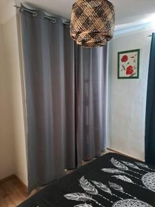 a bedroom with a bed and a gray curtain at Agréable T2 Classé 3 étoiles, refait à neuf, dans quartier calme in Rodez