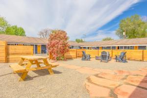 a picnic table and chairs in front of a fence at Minecart Motor Lodge in Montrose