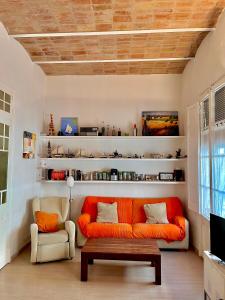 a living room with an orange couch and a coffee table at Apartamento Tramuntana de Portbou in Portbou