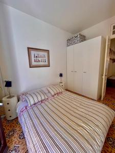 a bedroom with a large bed with a striped blanket at Apartamento Tramuntana de Portbou in Portbou