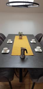 盧比安納的住宿－AppPrusnik，黄色餐巾纸上带茶壶的黑桌